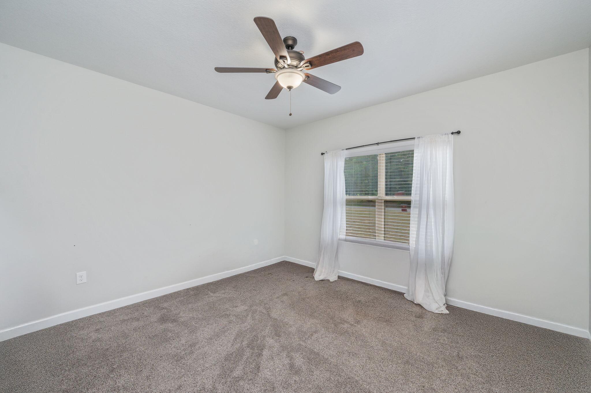 3501 Plympton Road Laurel Hill, FL 32567 - Photo 15 of 26 an empty room with ceiling fan and window