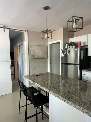 a kitchen with kitchen island a counter and refrigerator