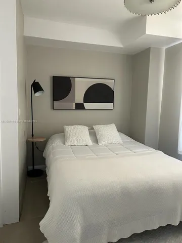 a bedroom with a bed and lamp