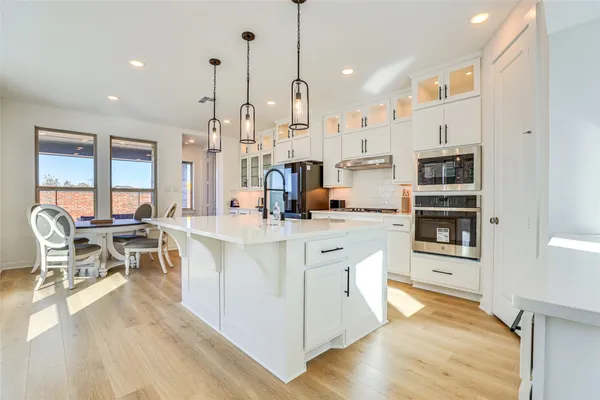 a open kitchen with stainless steel appliances granite countertop a stove and a wooden floors