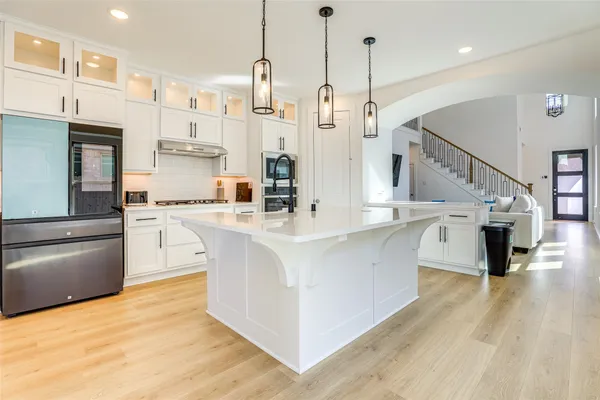 a kitchen with stainless steel appliances kitchen island granite countertop a sink a stove and a refrigerator