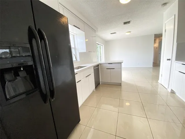 a kitchen with a refrigerator sink and cabinets