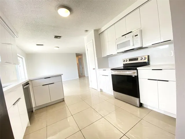 a kitchen with granite countertop a stove top oven and cabinets