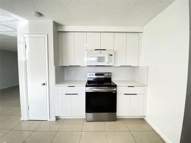 a kitchen with a stove top oven and cabinets
