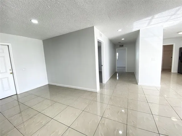 a view of hallway with a window and a refrigerator