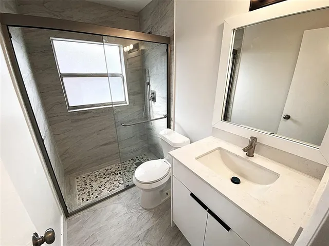 a bathroom with a sink toilet and shower