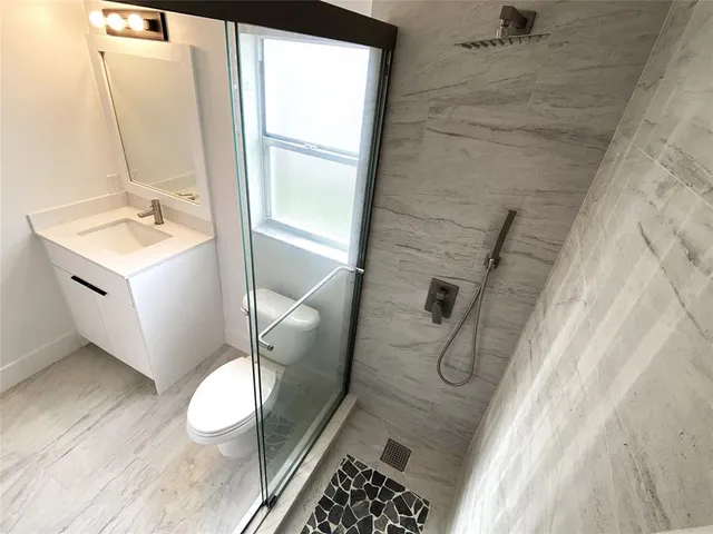 a bathroom with a sink toilet and shower