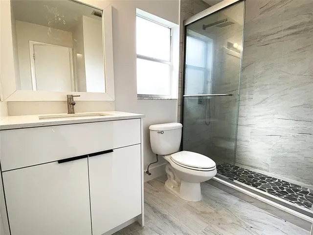 a view of a big yard with plants and a bench