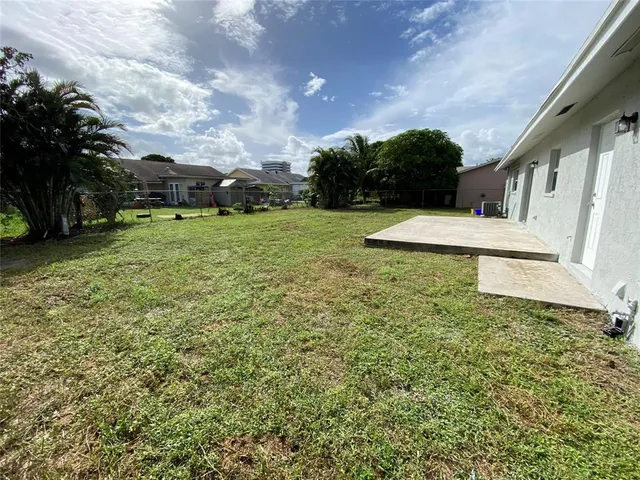 a view of an house with backyard and trees