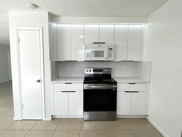 a kitchen with cabinets and appliances