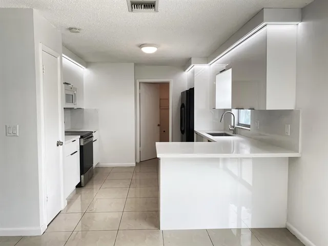 a kitchen with a sink a stove and a refrigerator