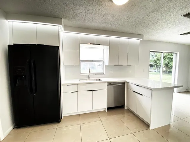 a kitchen with white cabinets a sink and a window