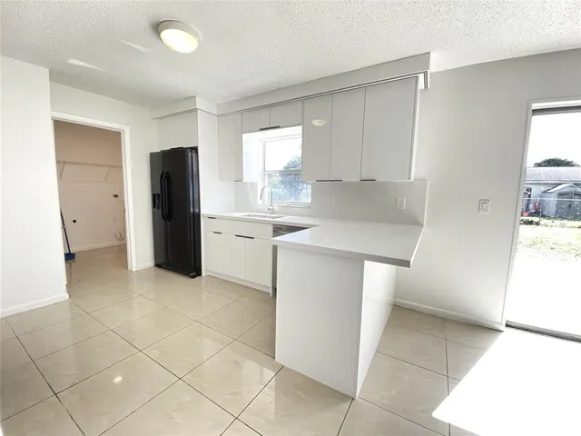 a kitchen with stainless steel appliances a refrigerator sink and cabinets