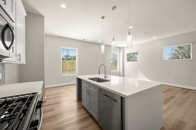 a kitchen with a sink stove and cabinets