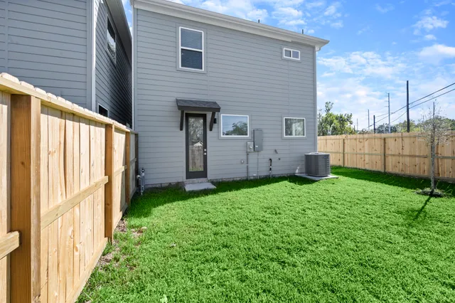 a view of backyard with barbeque grill and wooden fence
