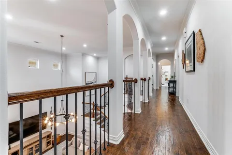 a view of a hallway with wooden floor and staircase