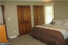 49239 Bennett Drive Ridge, MD 20680 - Photo 7 of 13 a bedroom with a bed and a mirror