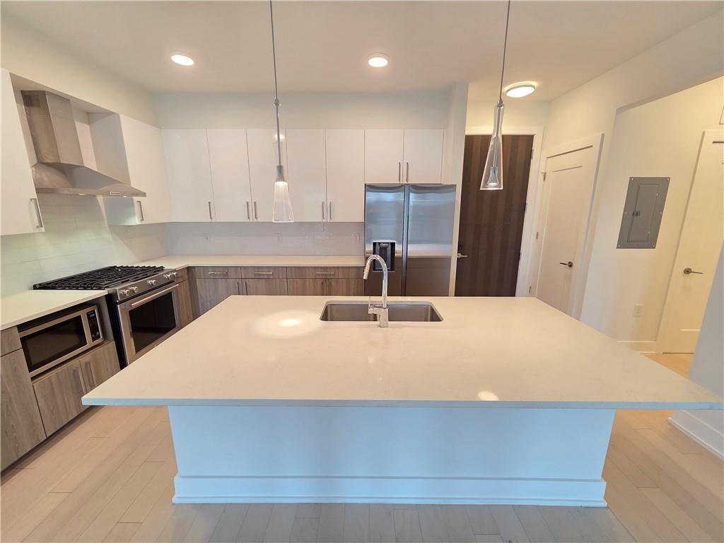 a kitchen with stainless steel appliances a refrigerator sink and microwave