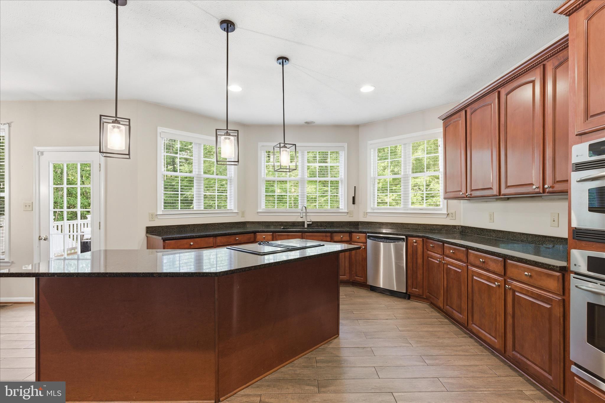 5829 Lockmere Place Waldorf, MD 20601 - Photo 20 of 54 a kitchen with stainless steel appliances granite countertop a sink a stove and a wooden floors