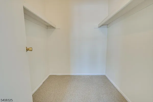 a spacious bedroom with a bed and a flat screen tv