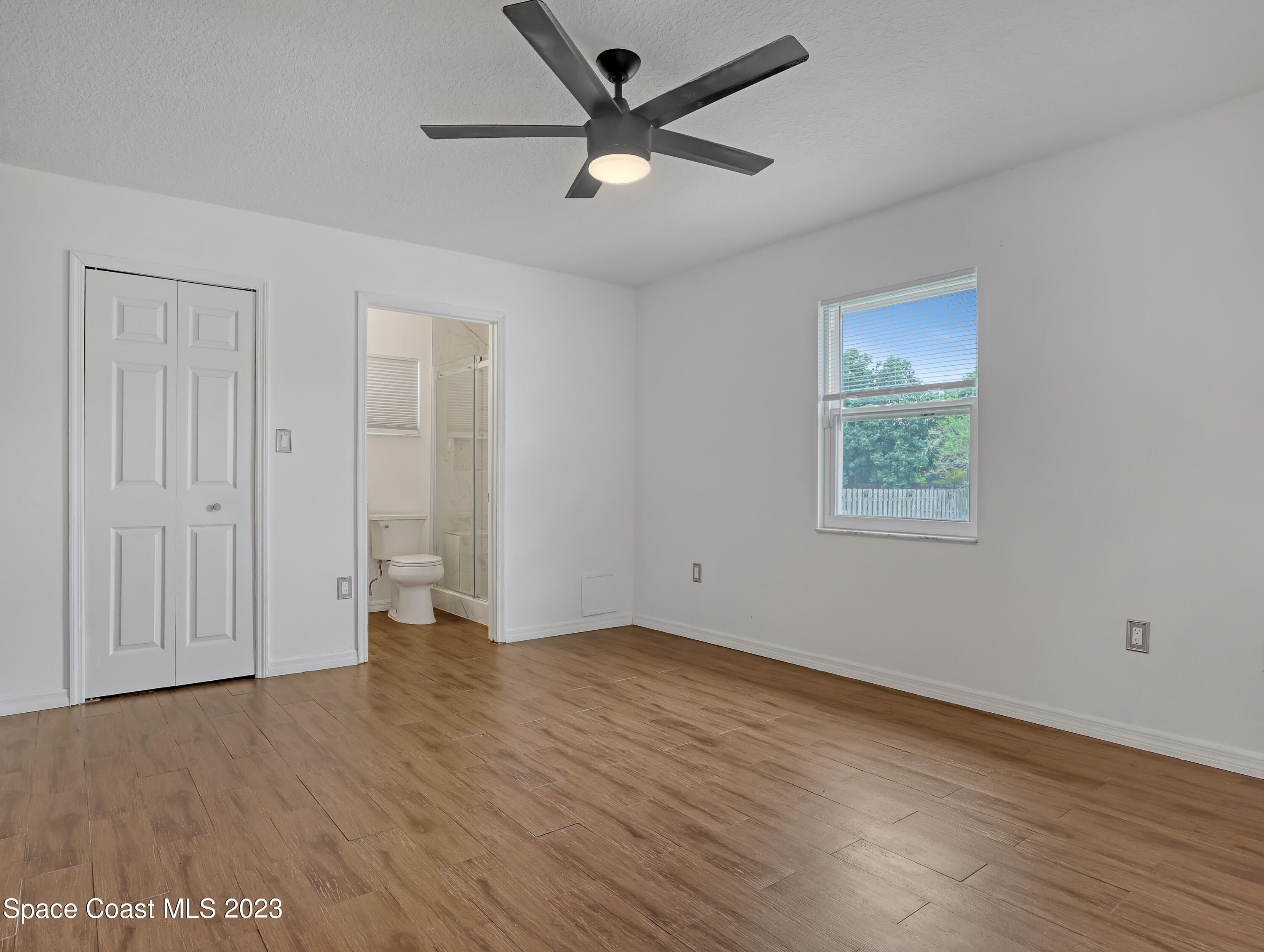 5233 Carrick Road Cocoa, FL 32927 - Photo 13 of 32 an empty room with wooden floor and windows