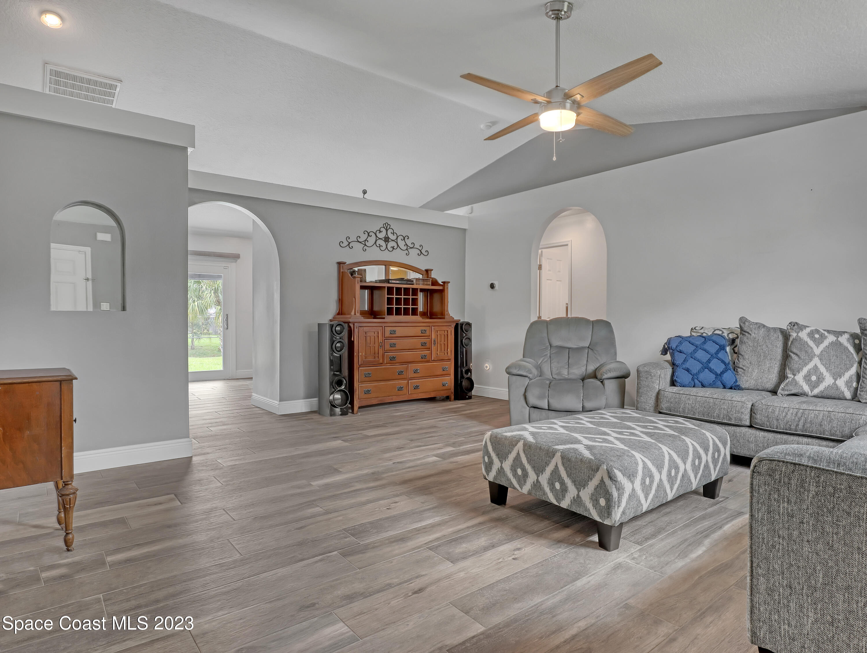 5233 Carrick Road Cocoa, FL 32927 - Photo 5 of 32 a spacious bedroom with a bed a couch and a chandelier