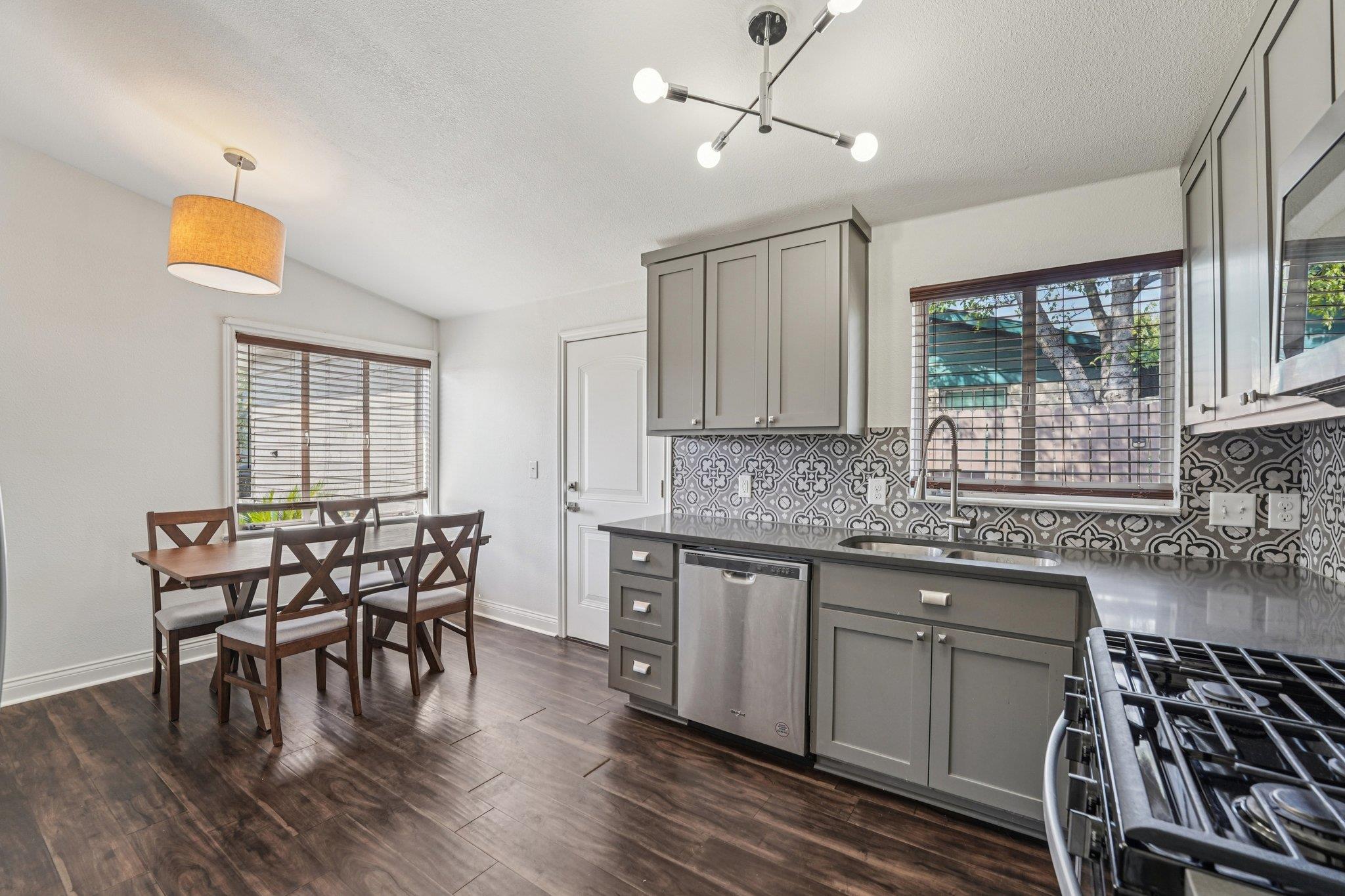 3705 Manorwood Road Austin, TX 78723 - Photo 6 of 13 a kitchen with stainless steel appliances granite countertop a dining table chairs stove and white cabinets
