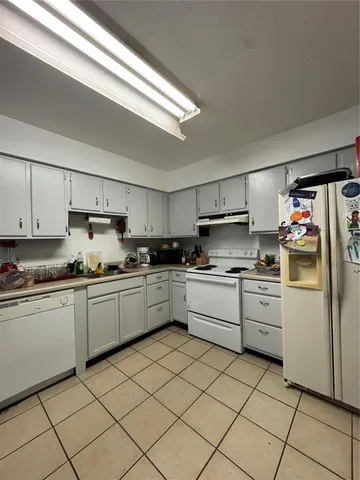 a kitchen with cabinets a sink and white stainless steel appliances