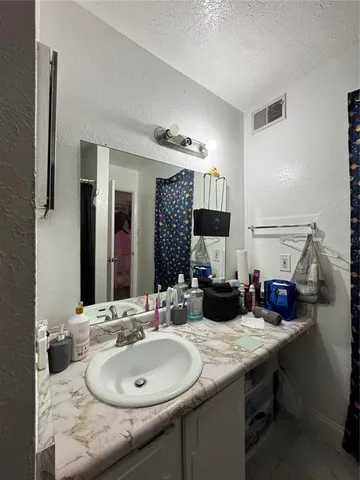 a bathroom with a granite countertop sink mirror and toilet