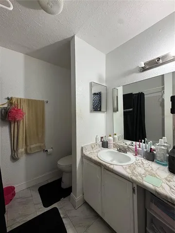 a bathroom with a granite countertop shower a sink and a mirror