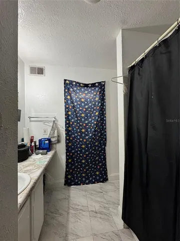 a bathroom with a shower and a sink