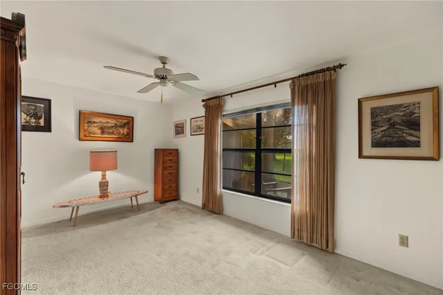 an empty room with windows and ceiling fan