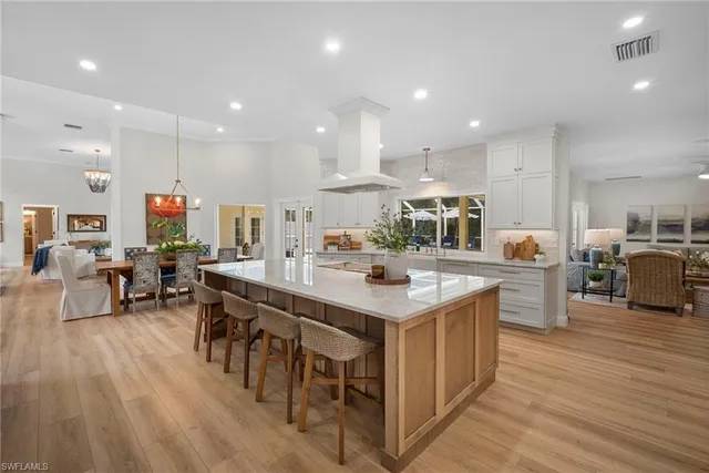 a large kitchen with a large counter top furniture a sink appliances and living room view