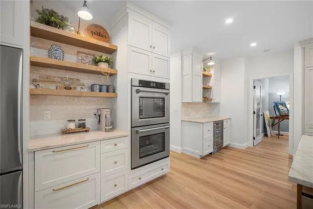 a kitchen with granite countertop white cabinets and stainless steel appliances