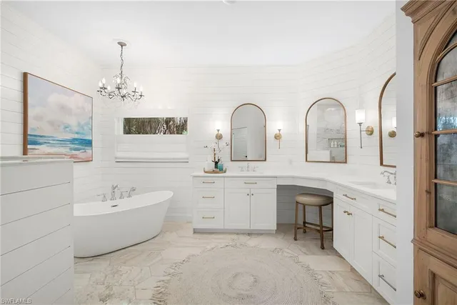 a spacious bathroom with double vanity a mirror a bathtub and double vanity