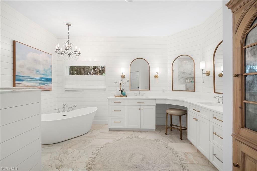 3110 70th Street Southwest Naples, FL 34105 - Photo 27 of 50 a spacious bathroom with double vanity a mirror a bathtub and double vanity