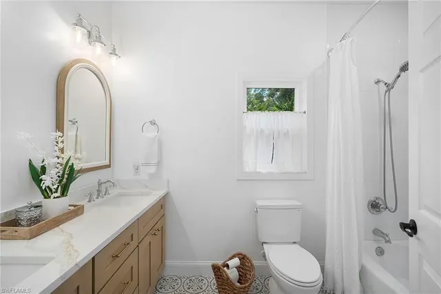 a bathroom with a granite countertop sink a toilet and shower
