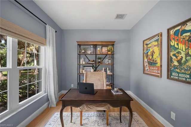 a view of a workspace with furniture and a window