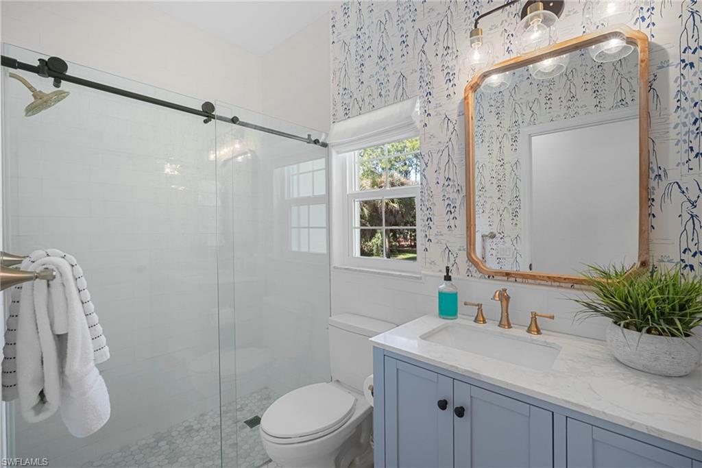 3110 70th Street Southwest Naples, FL 34105 - Photo 43 of 50 a bathroom with a sink a mirror a toilet and shower