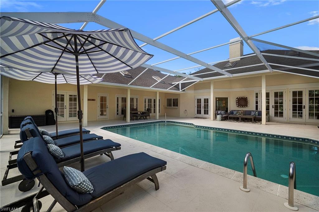 3110 70th Street Southwest Naples, FL 34105 - Photo 48 of 50 a view of a patio with chairs and a table under an umbrella
