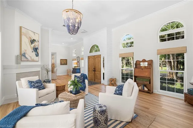 a living room with furniture chandelier and a window