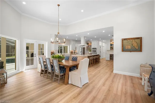 a dining room with furniture a chandelier and wooden floor