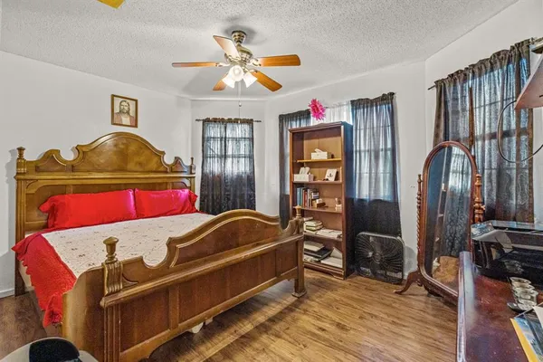 a bedroom with bed and wooden floor