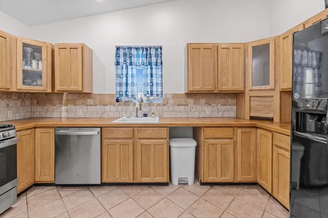 a kitchen with stainless steel appliances granite countertop a refrigerator and a sink