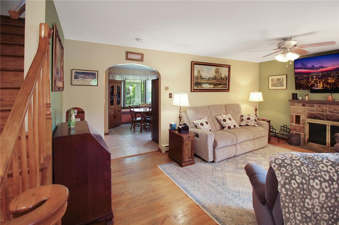 1256 Ridge Avenue Whitehall, PA 18052 - Photo 15 of 43 Hardwood floors complement a cozy living space with a classic fireplace and staircase.