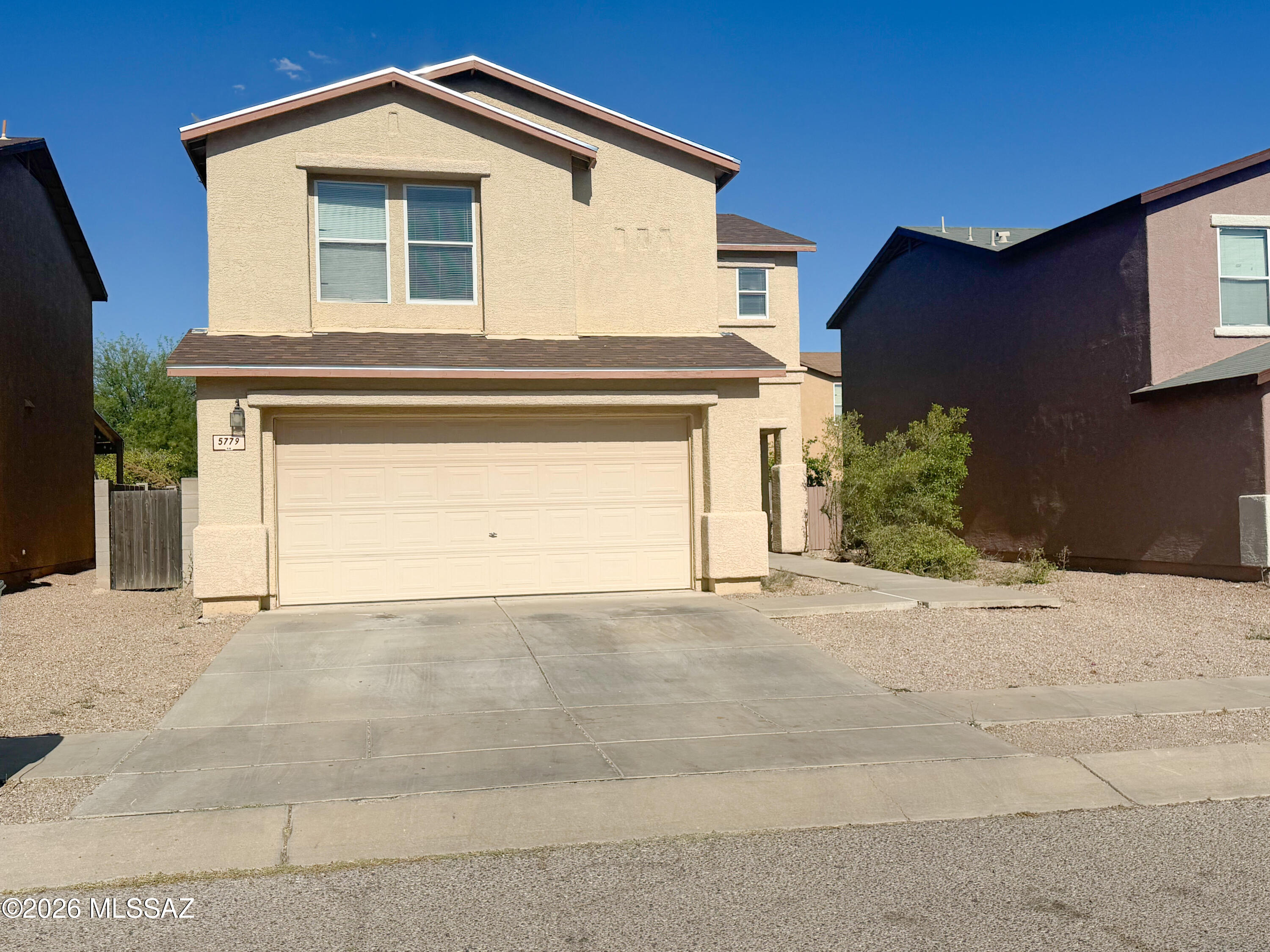 5779 South Manta Ray Road Tucson, AZ 85706 - Photo 2 of 30 a front view of a house with a yard and garage