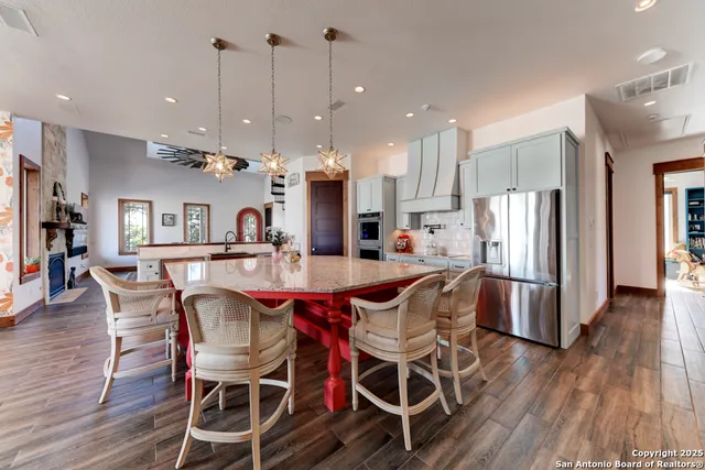 a kitchen with granite countertop white cabinets and stainless steel appliances