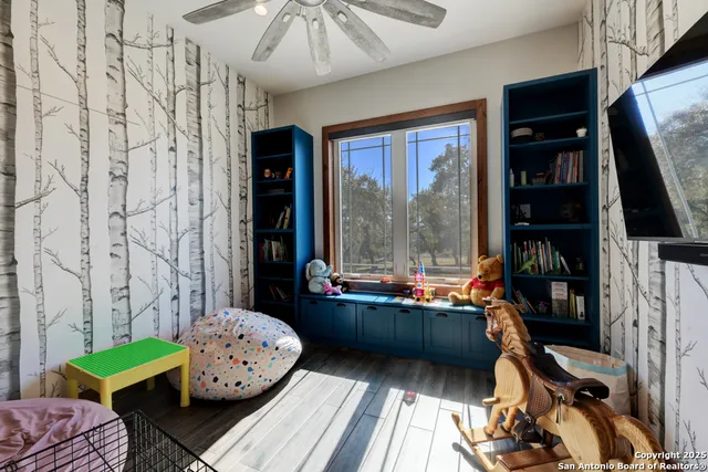 a room with furniture a rug potted plant and a window