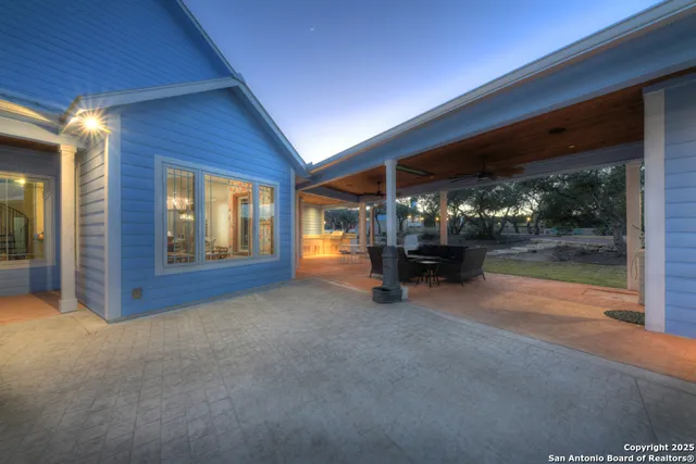 a view of a patio with table and chairs and floor to ceiling window