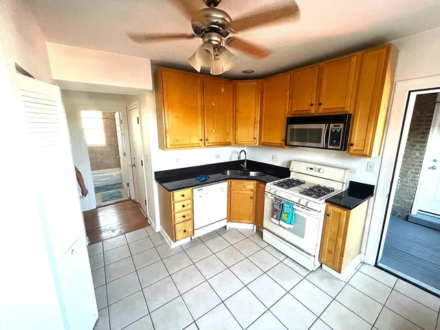 a kitchen with stainless steel appliances a stove a sink a microwave a refrigerator cabinets and furniture